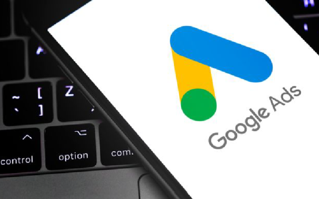 Smartphone screen showing Google Ads logo on top of a keyboard, representing mobile access to Google account advertising tools.